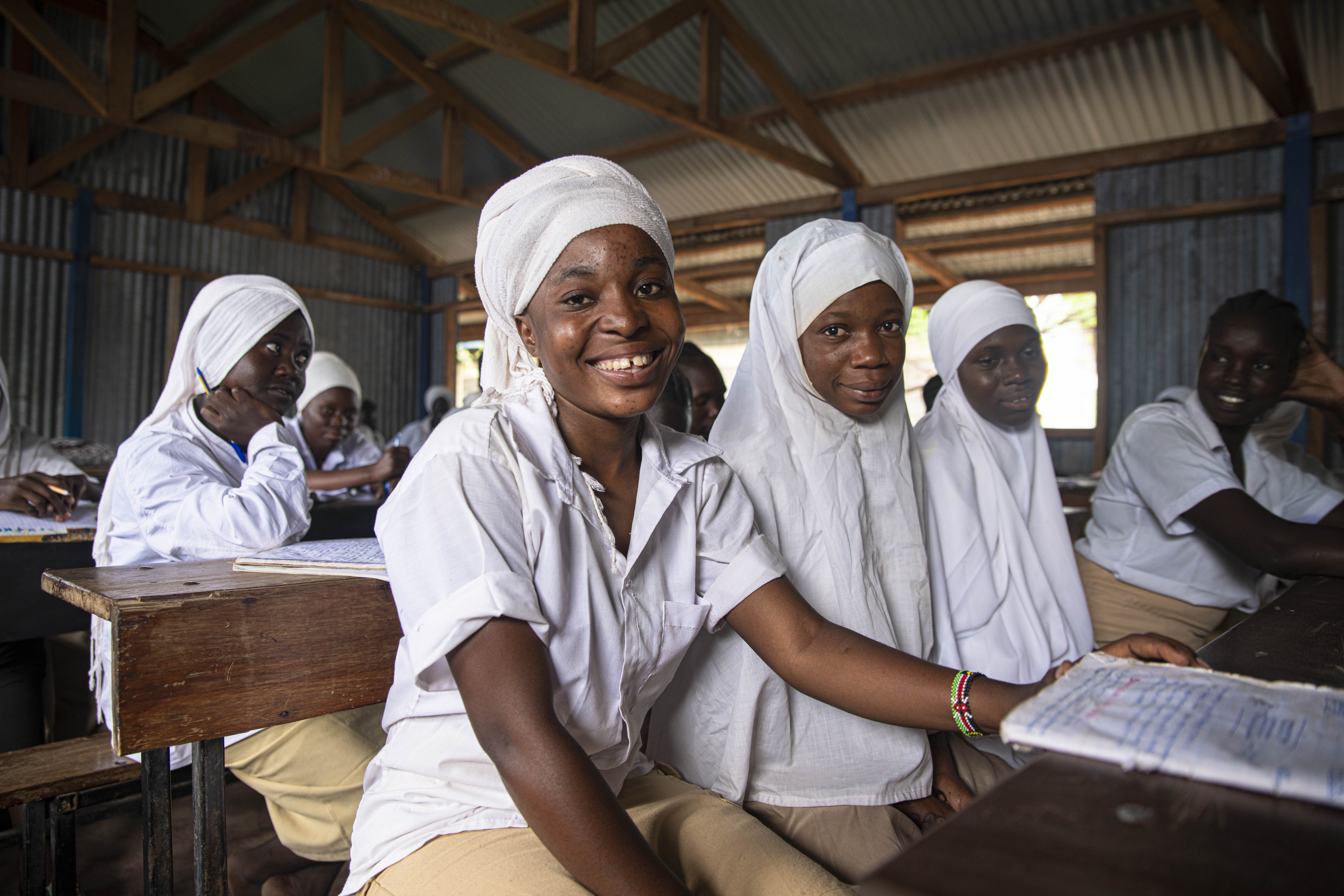 Refugee students smile at camera. In Kakuma Refugee Camp, UNHCR is advocating for technical support and financing for the inclusion of refugees and camp-based schools in the national education system.