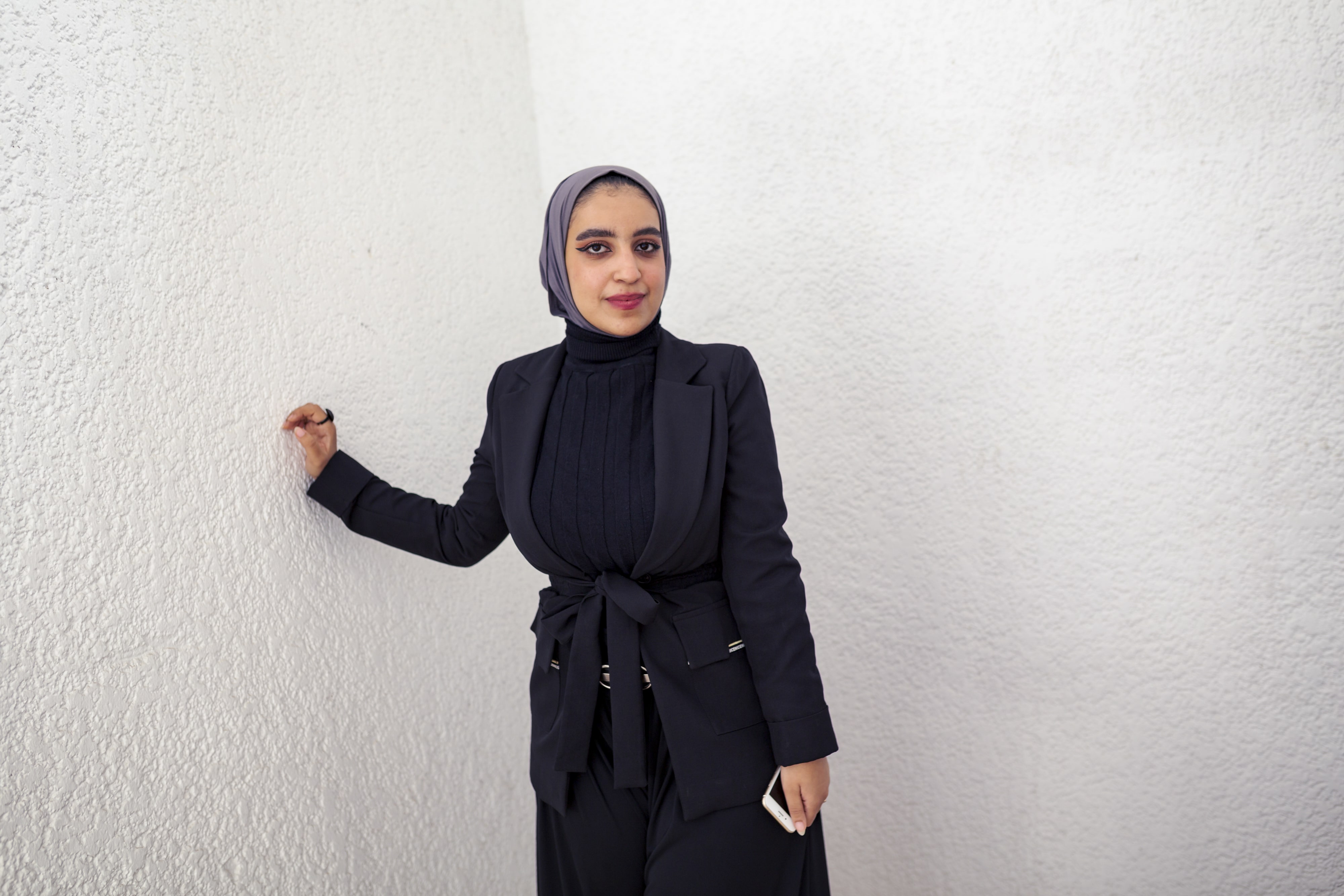 Young woman leans against wall. Fatima, from Yemen is a third-year student of Medicine at Cairo University, on a DAFI scholarship.