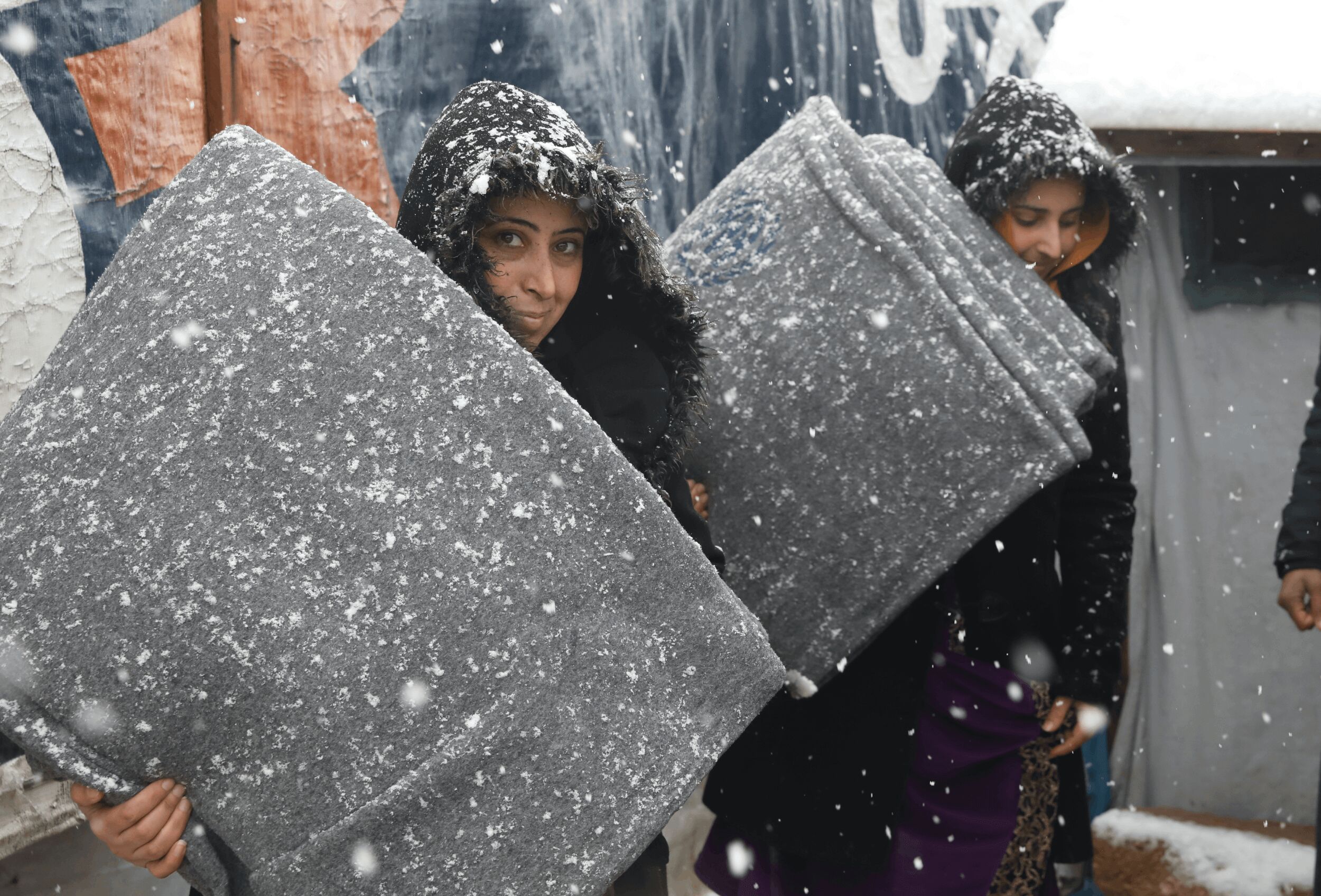 Two women receive thermal blankets as part of UNHCR's winter assistance in Lebanon.